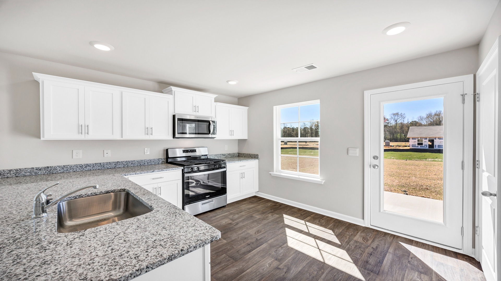 The Perry kitchen with white cabinetry and granite countertops.