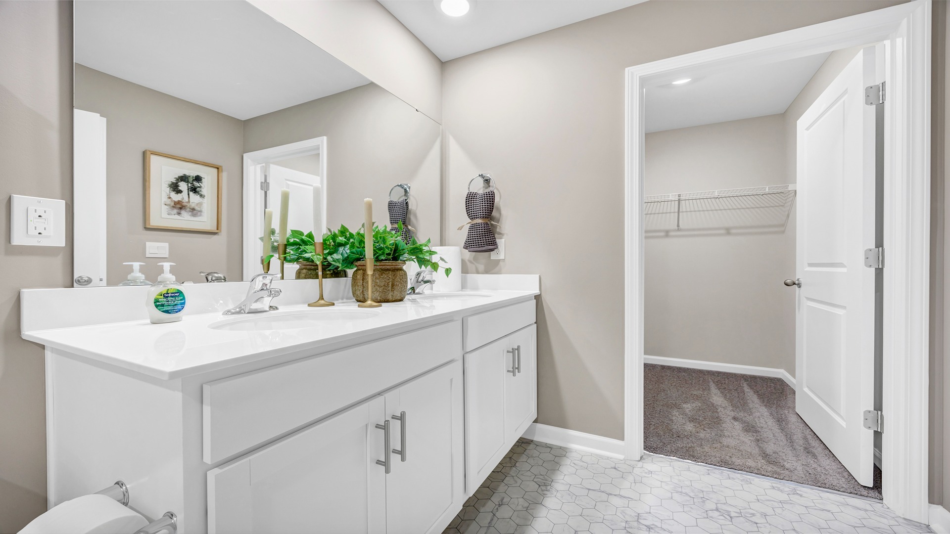 Double primary vanity with quartz countertops and white cabinets below