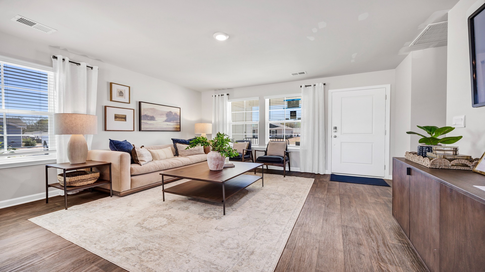 Living area right off the front entrance with vinyl floors and windows for natural light