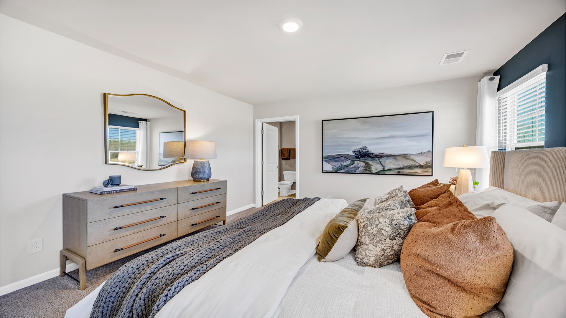 Spacious primary bedroom fits furniture and king bed set comfortably