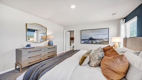 The primary bedroom is spacious with several windows.