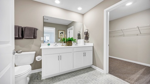 The primary bathroom features double sinks and a walk-in closet.