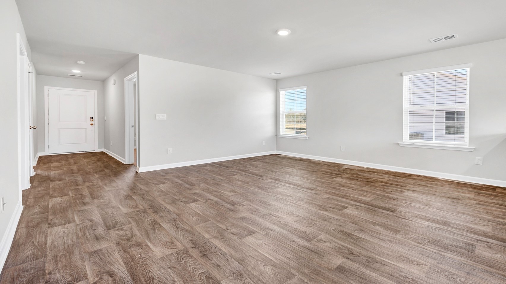 Front entrance leads into the open living area with windows for natural light
