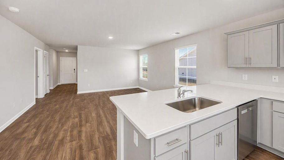 Kitchen bar overlooks the open living area with matching vinyl floors