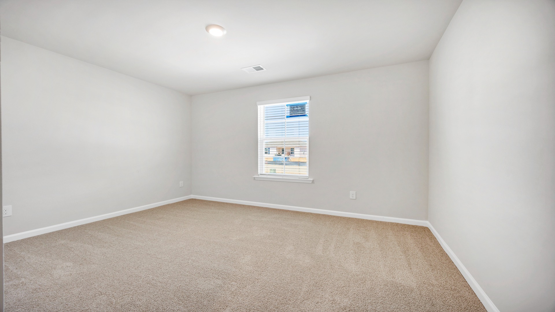 Bedroom 2 with a window for light and carpet flooring