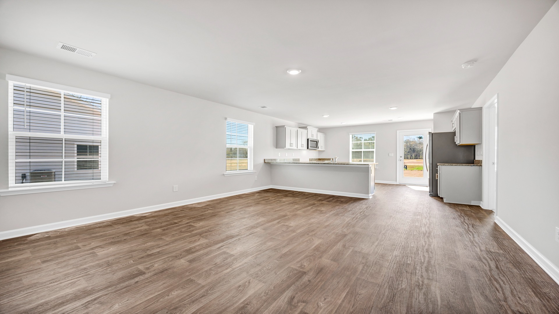 Open living and kitchen spaces with matching vinyl flooring
