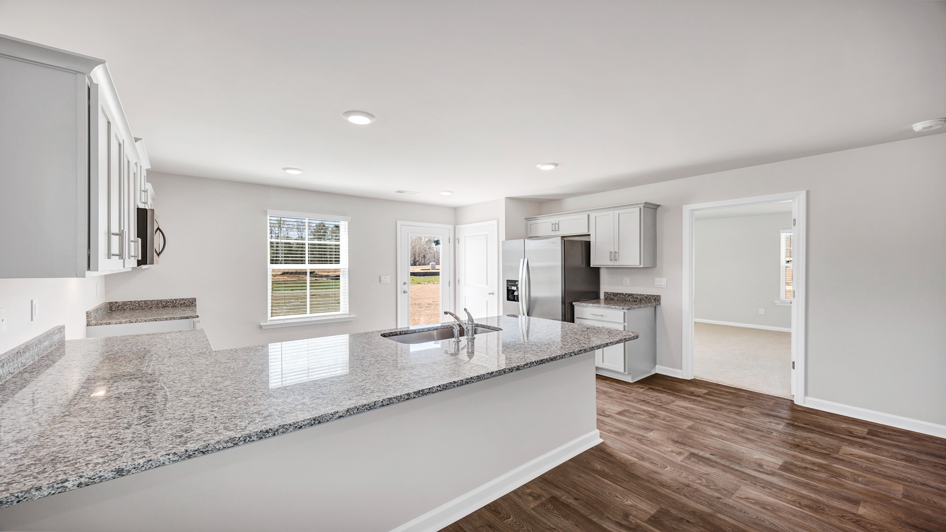 Access to the primary bedroom off the kitchen space at the back of the home