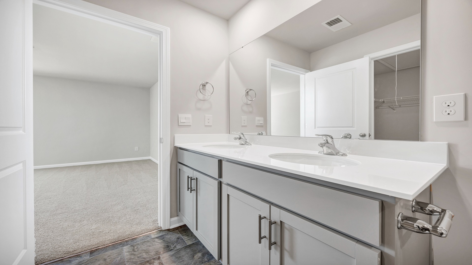 Double primary vanity with gray cabinetry and quartz countertops