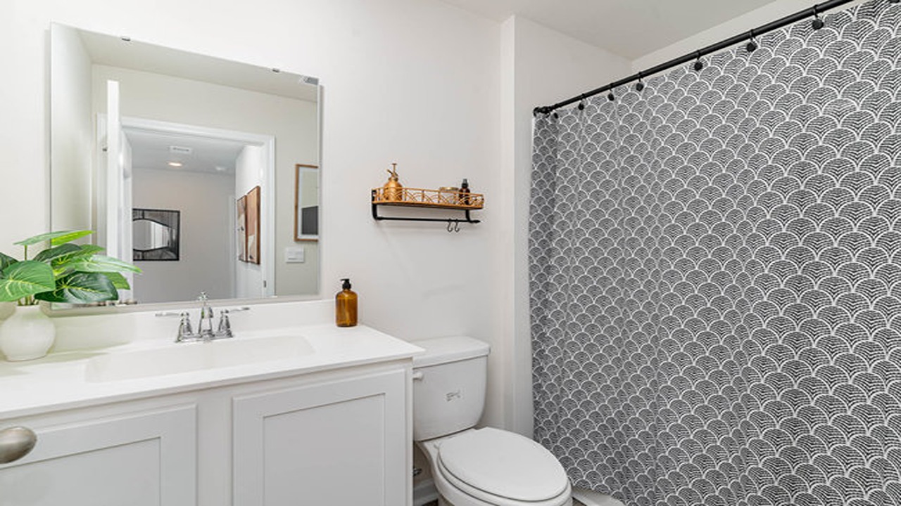 Bathroom 2 features a shower tub combo and white cabinetry.