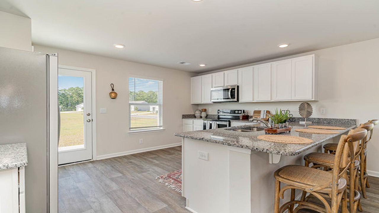 There are several windows in the kitchen, including one on the door that leads to the back patio.