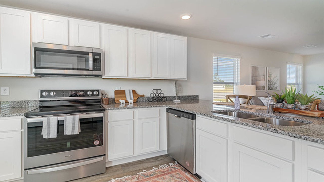 The Lewis kitchen with modern granite countertops and white cabinetry.