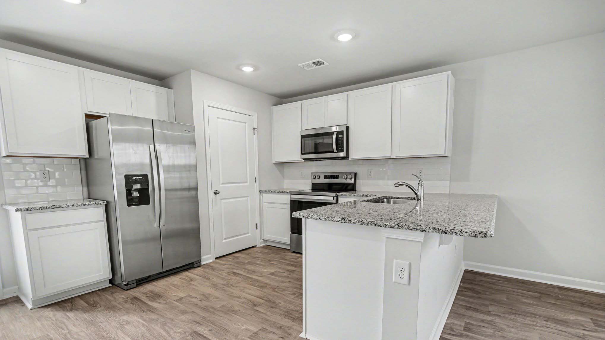 Ranger kitchen area with white cabinetry and a kitchen bar
