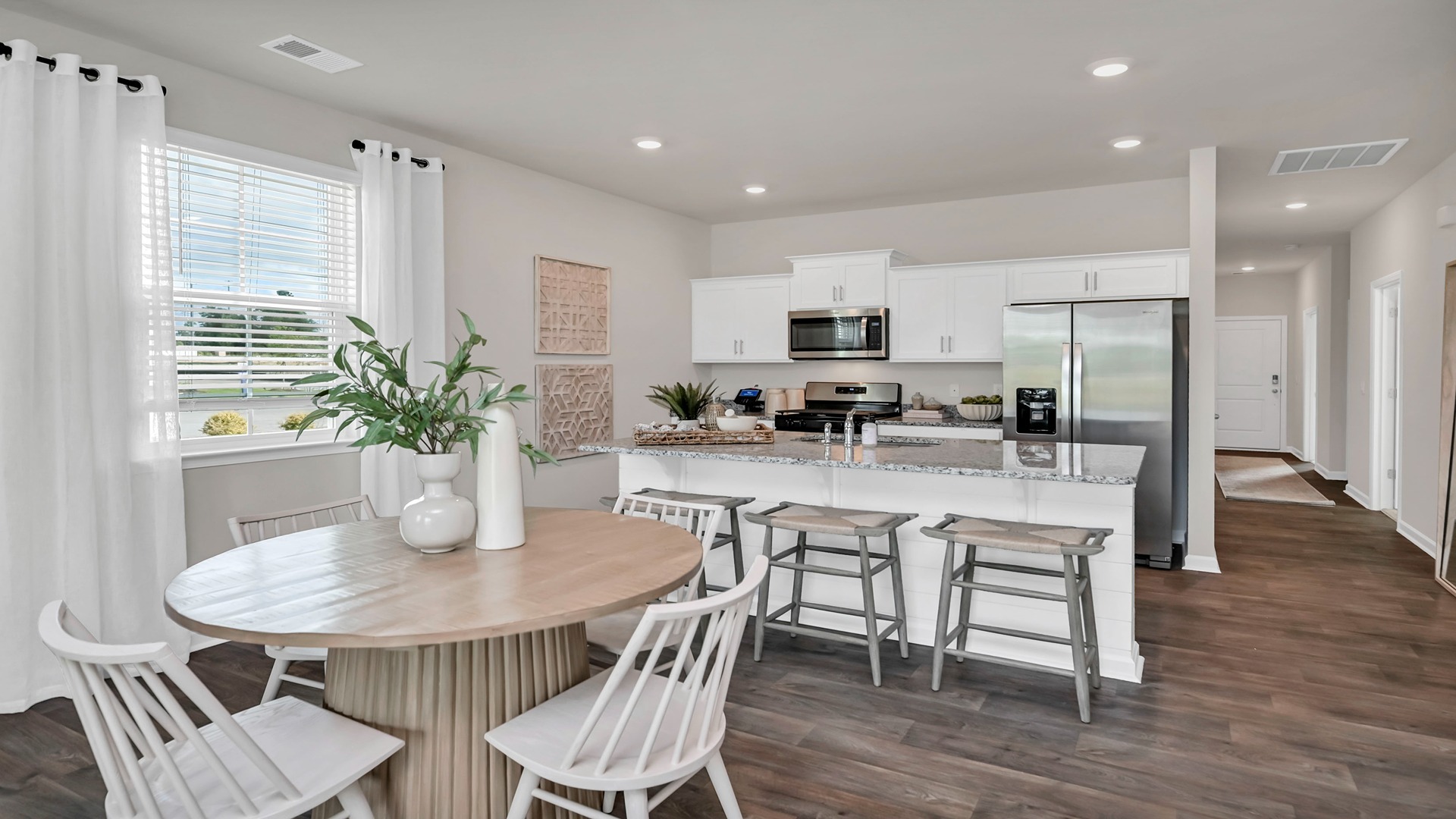 Open concept dining and kitchen areas with vinyl flooring