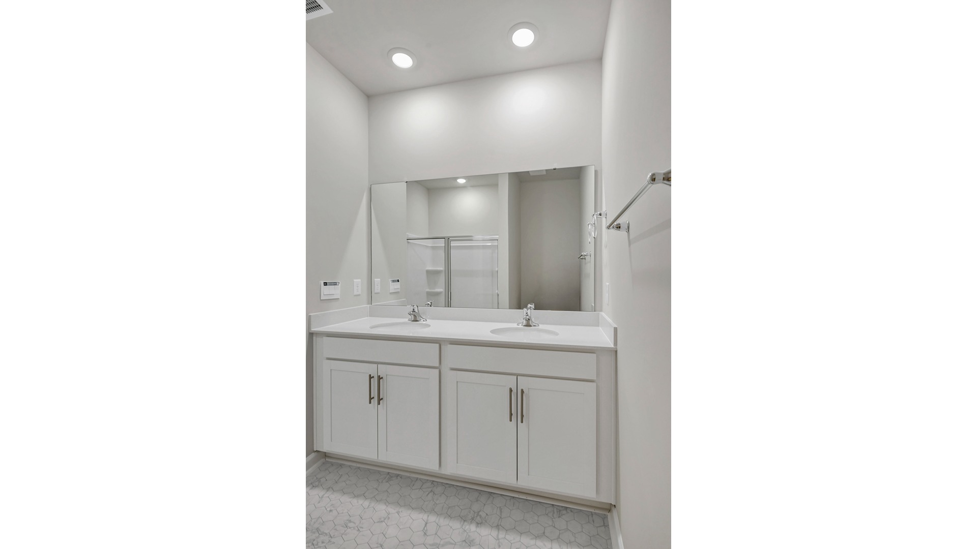 Double primary bathroom vanity with quartz counters and white cabients
