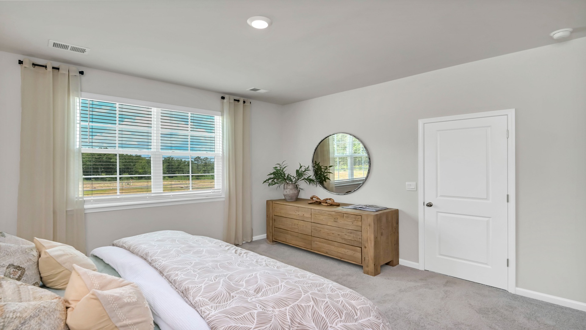 The primary bedroom features carpet flooring and a large window