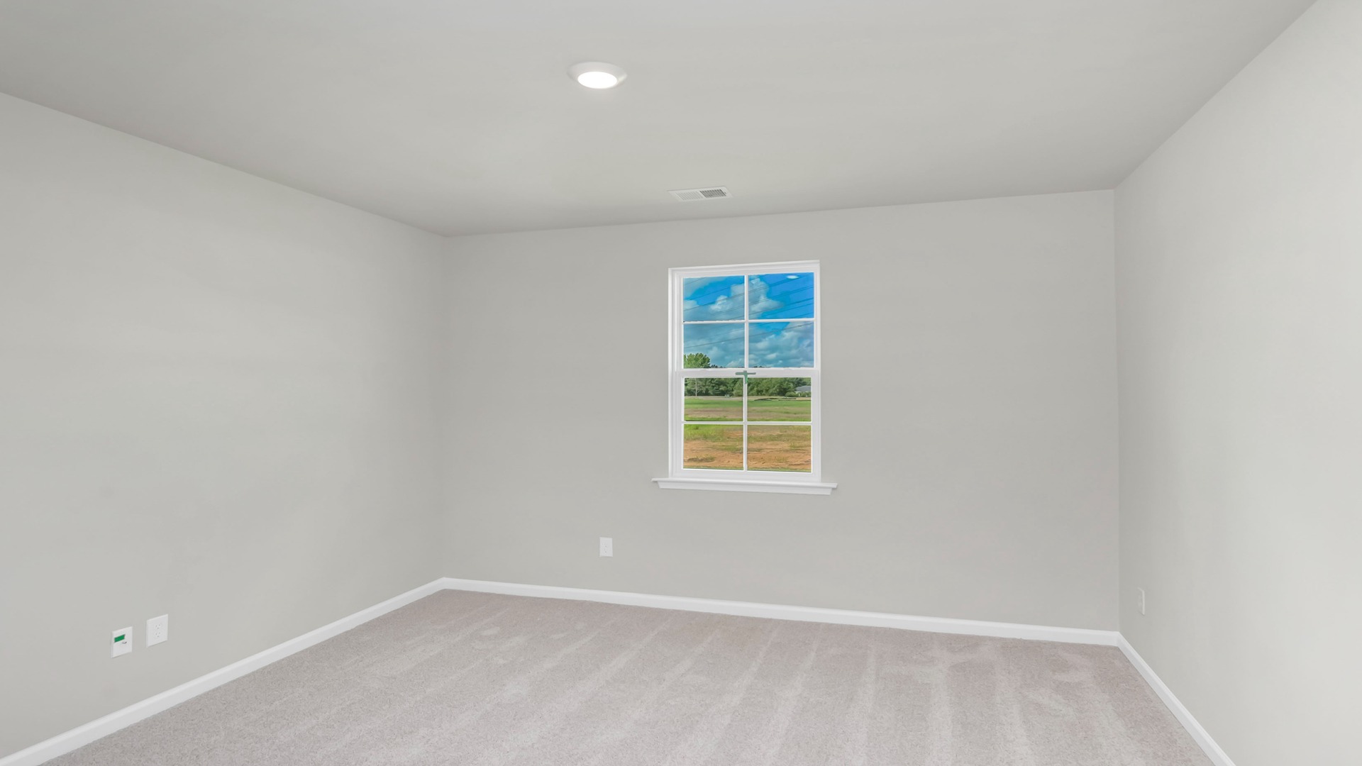 Natural light and carpet flooring in primary bedroom