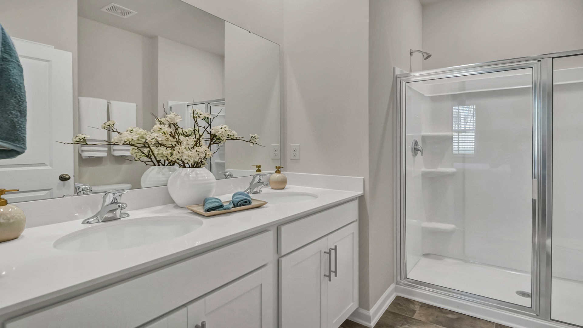 En-suite primary bathroom with walk-in shower and double vanity with quartz countertops