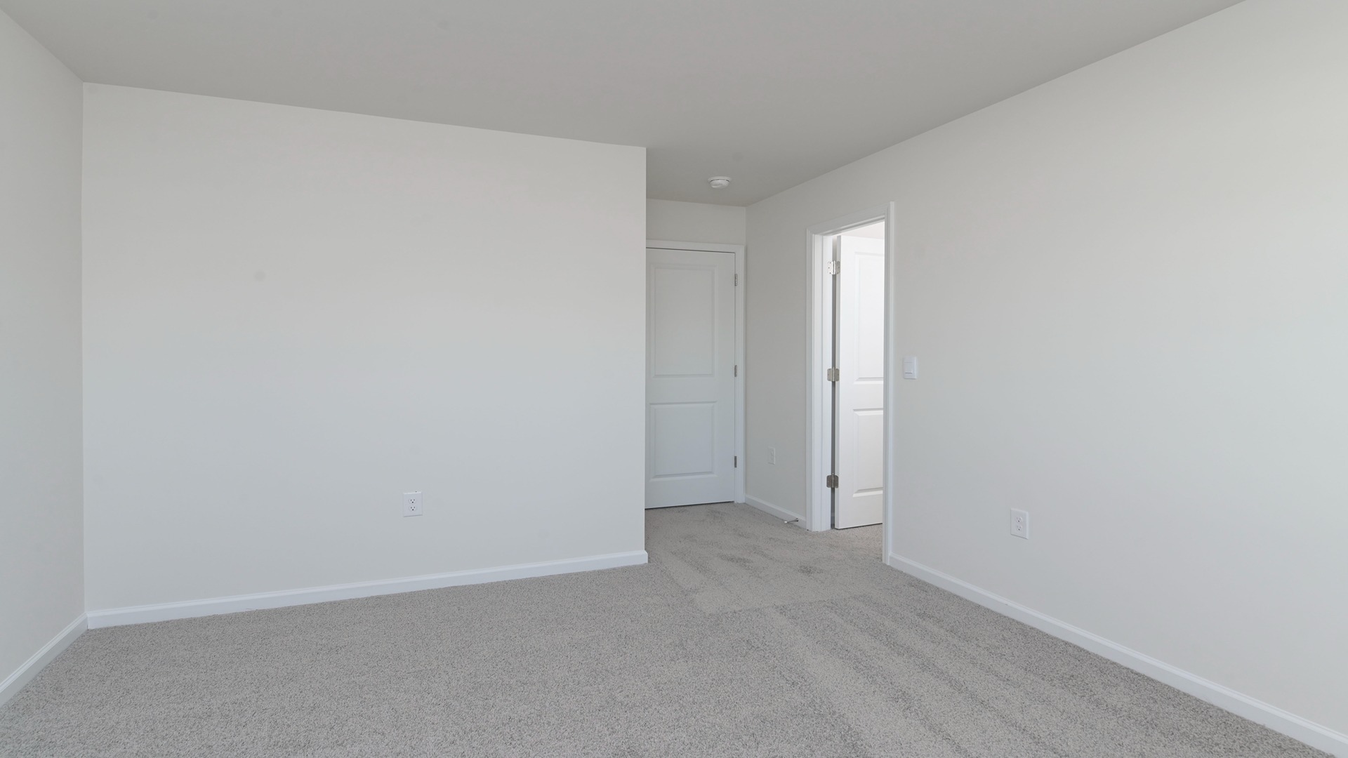 Carpet floors and a primary closet in bedroom 2 of the Harrison floorplan