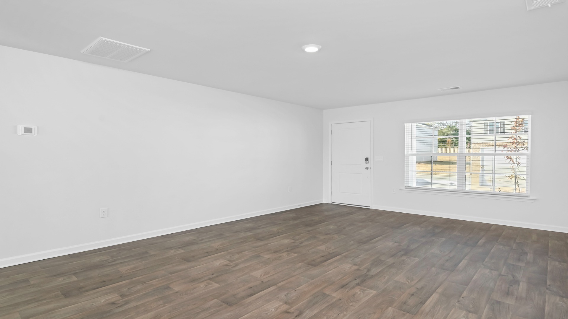 Open living area with large window overlooking the front porch and yard