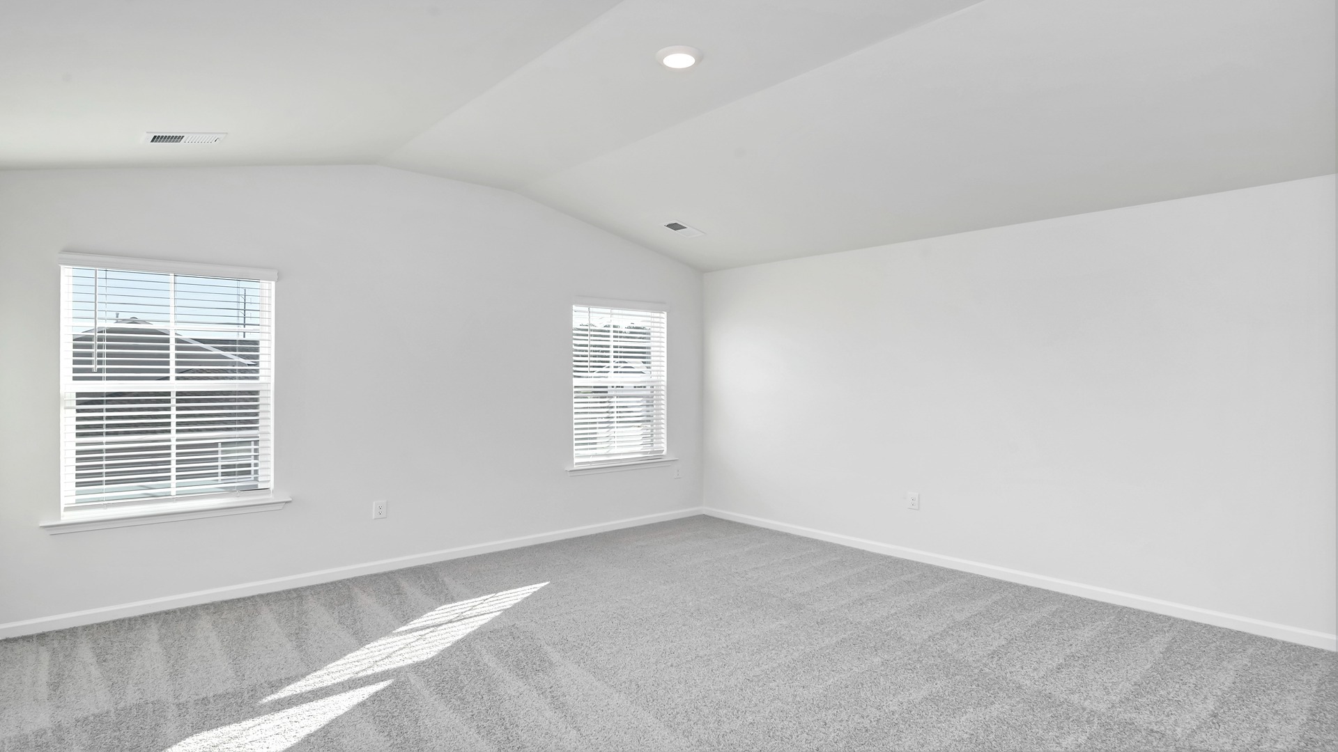 Primary bedroom upstairs with 2 windows and carpet flooring