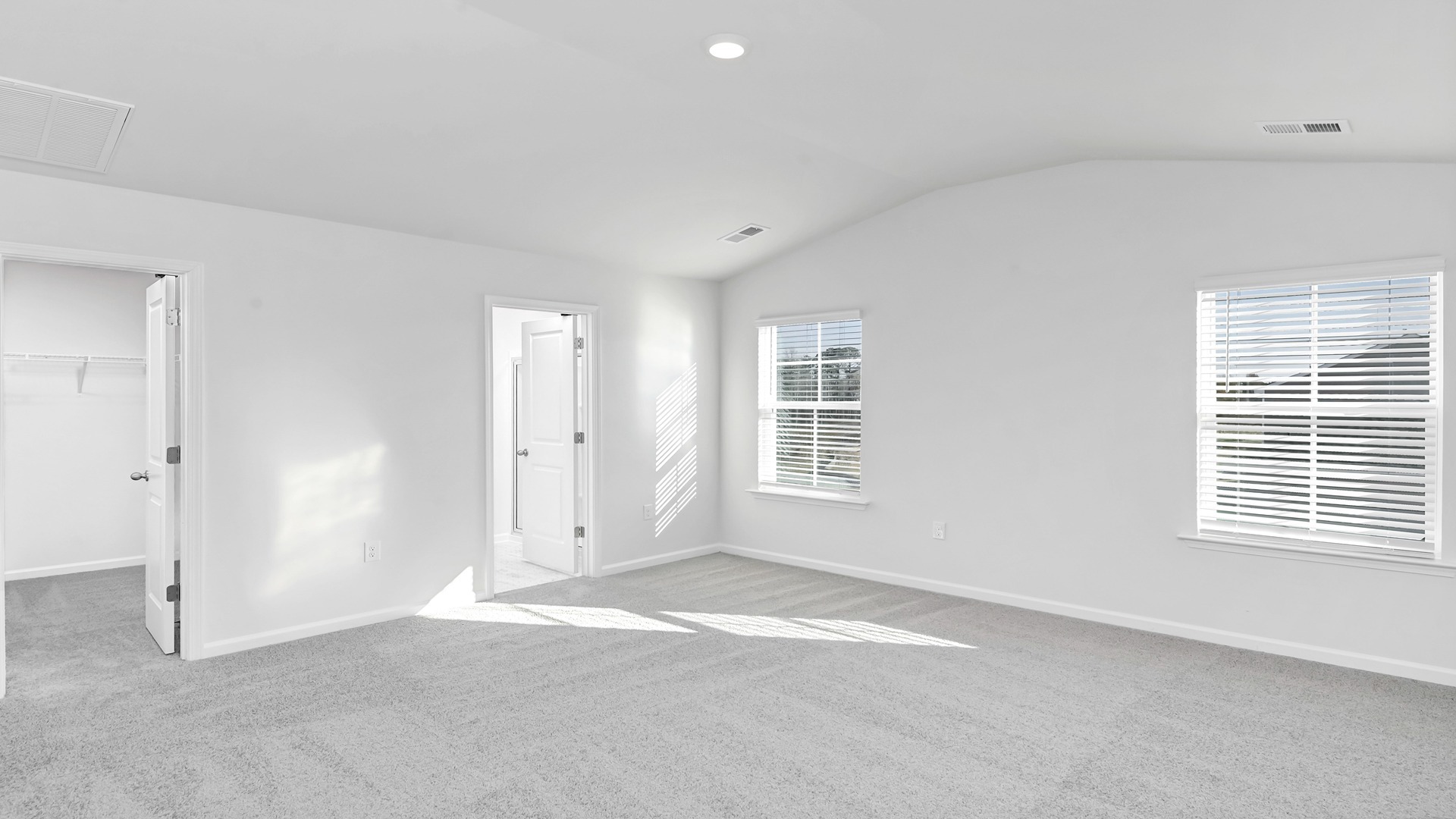 Spacious primary suite with large windows and modern finishes