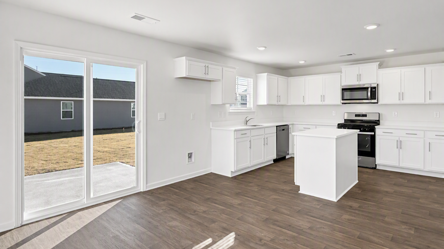 Open concept dining and kitchen areas in the Harrison floor plan for sale in Ferry Grove