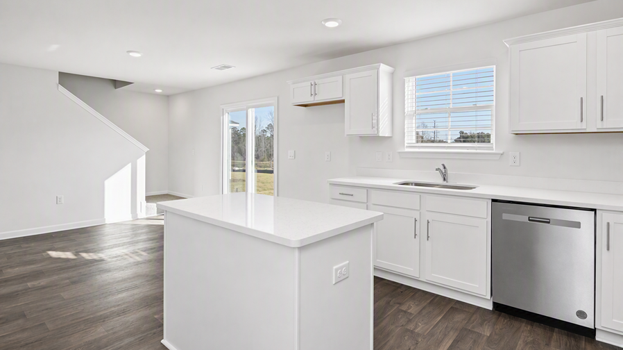 Small floating island in kitchen and a window for natural light over the sink