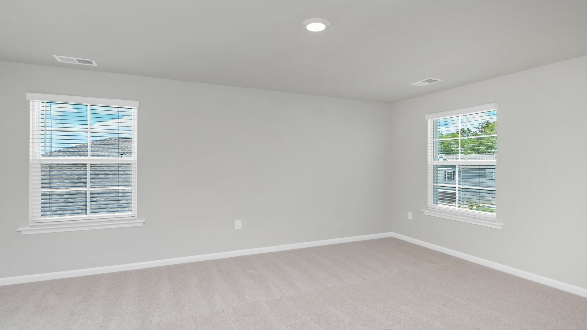 Primary bedroom upstairs with carpet flooring and 2 windows