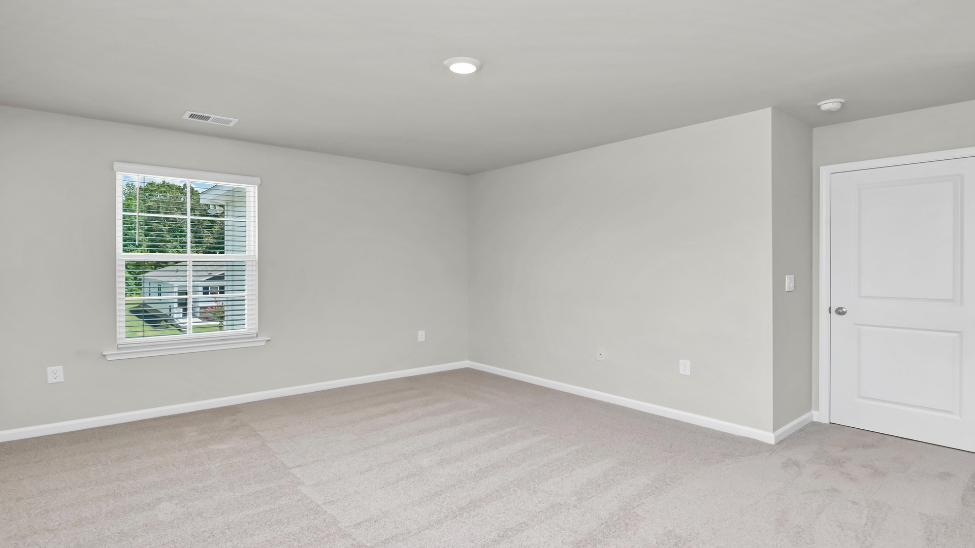 Carpet flooring and neutrally painted walls in primary bedroom