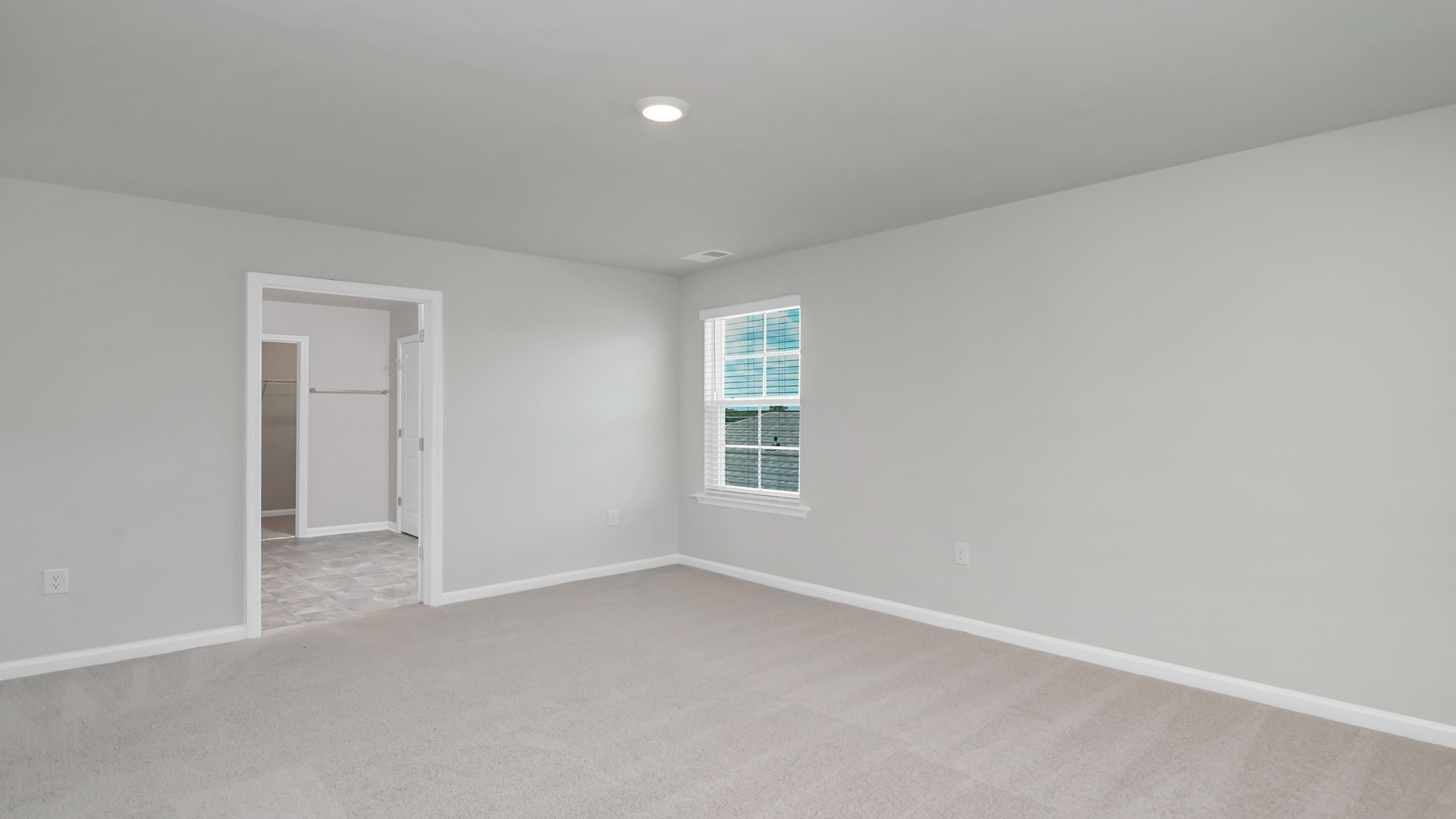 Primary bedroom with direct access to en-suite bathroom and walk-in closet