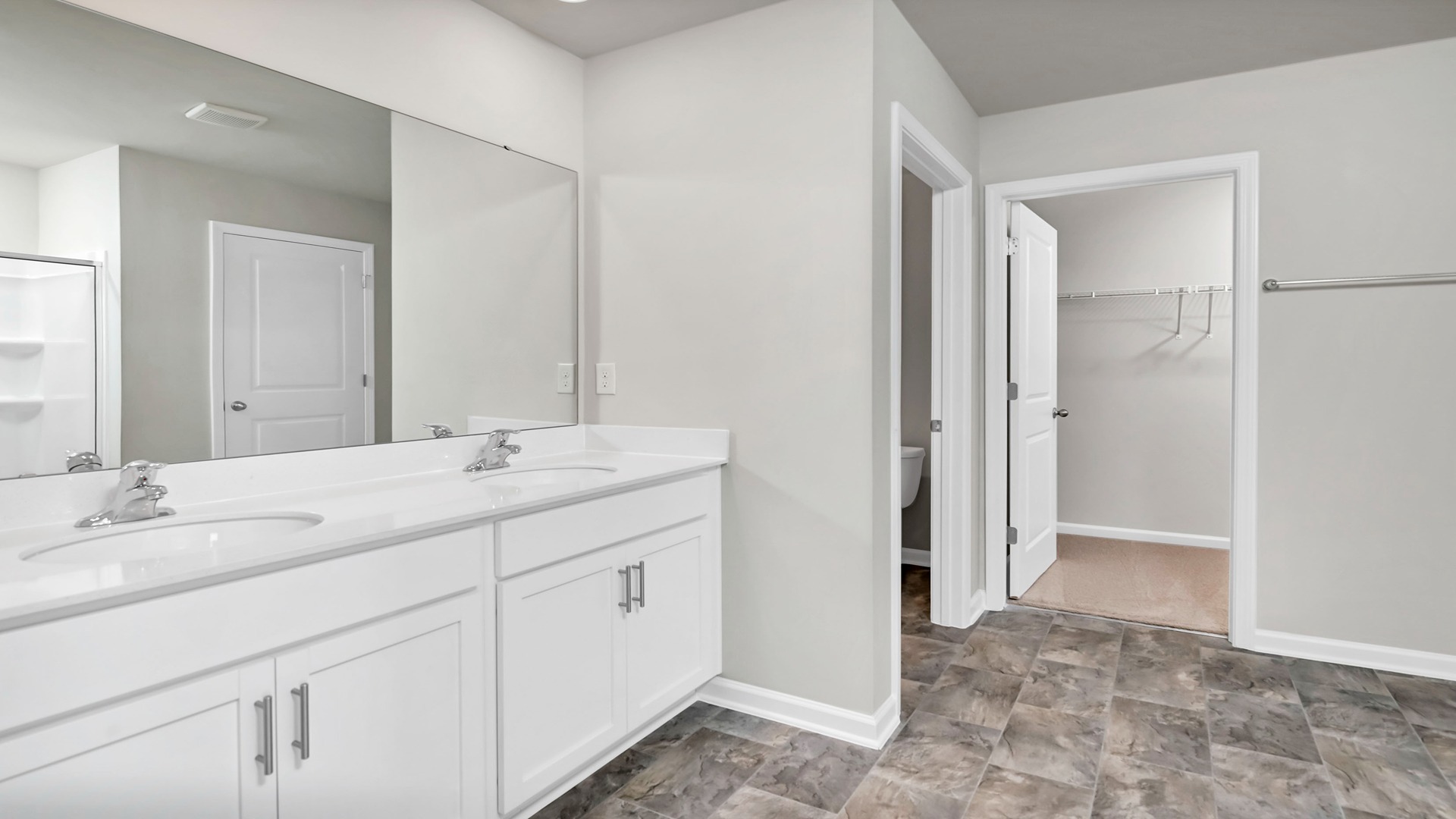 En-suite primary bathroom with double vanity and walk-in closet