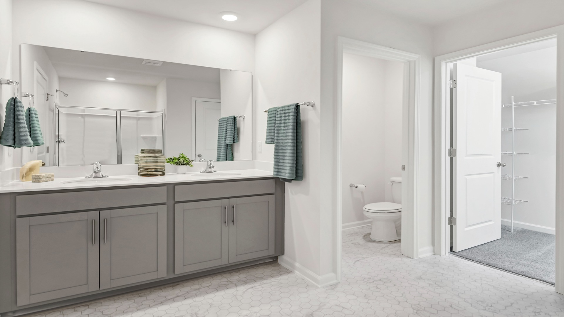 En-suite primary bathroom with double vanity and walk-in closet