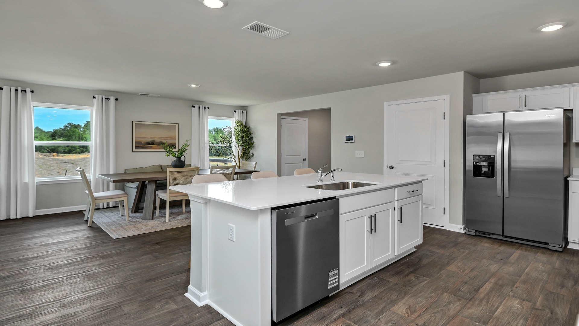 Floating kitchen island in available home overlooks the dining area