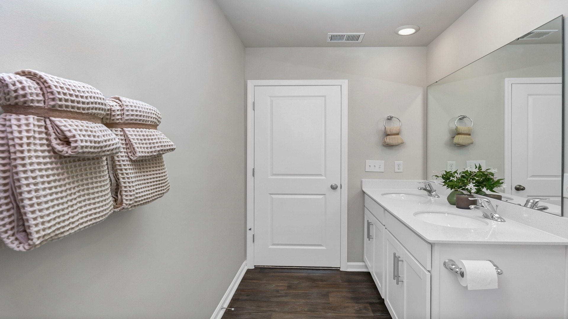White cabinets and white quartz countertops on all bathroom vanities in this available home