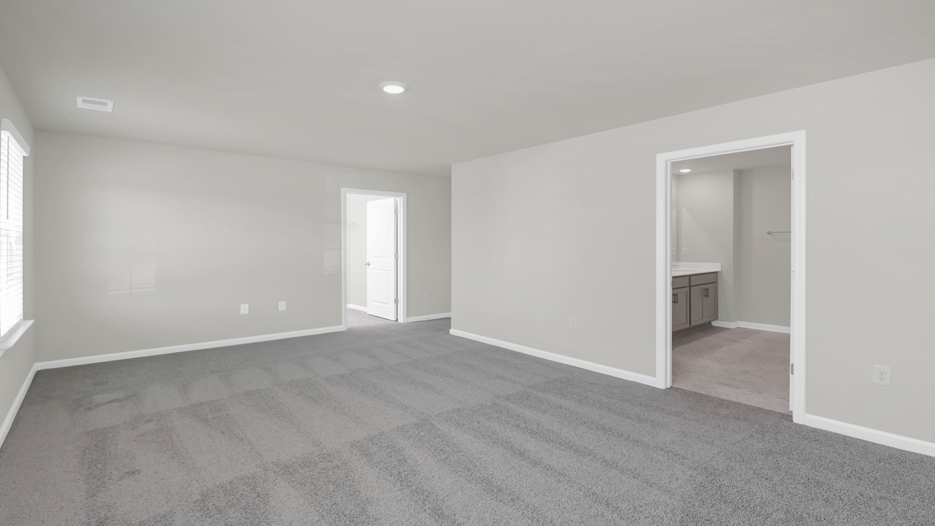 Primary bedroom upstairs with carpet floors and several windows