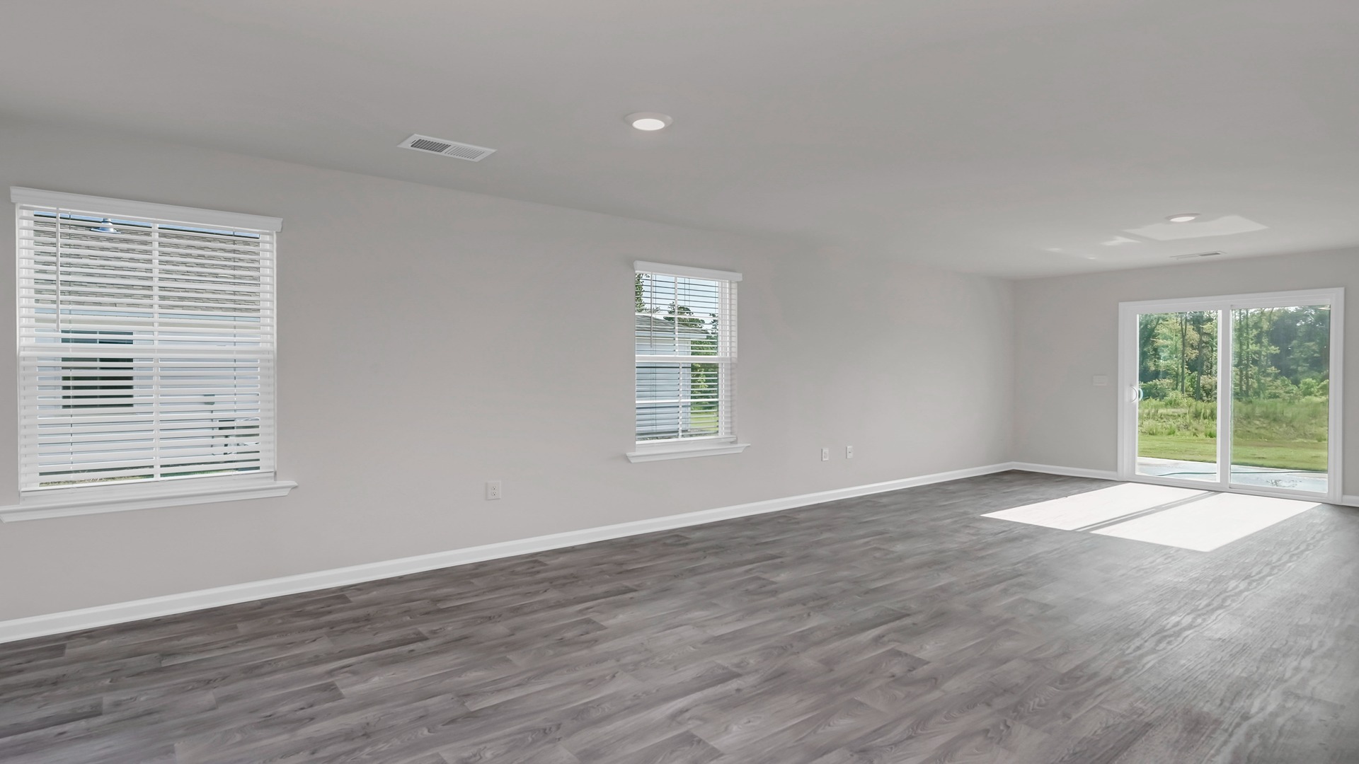 The living area is spacious with several windows and a sliding door
