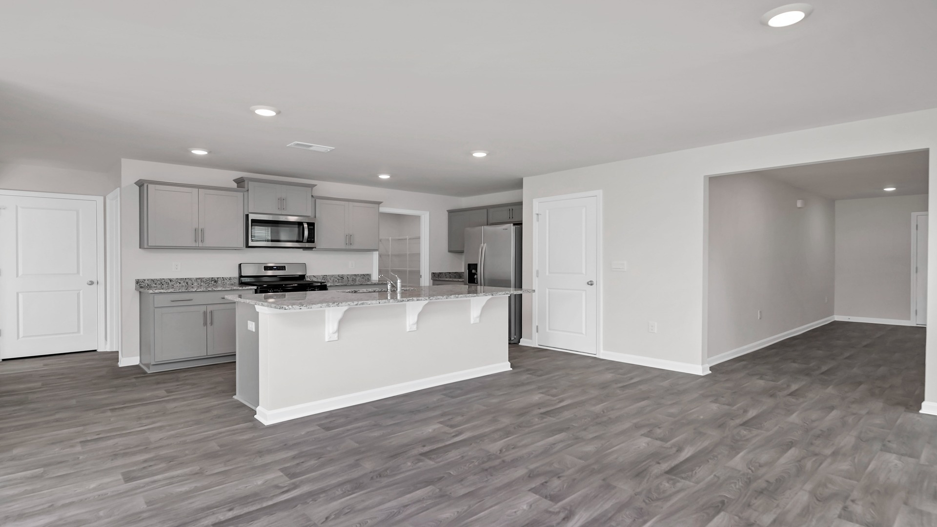 The kitchen and dining areas are open concept with matching vinyl flooring