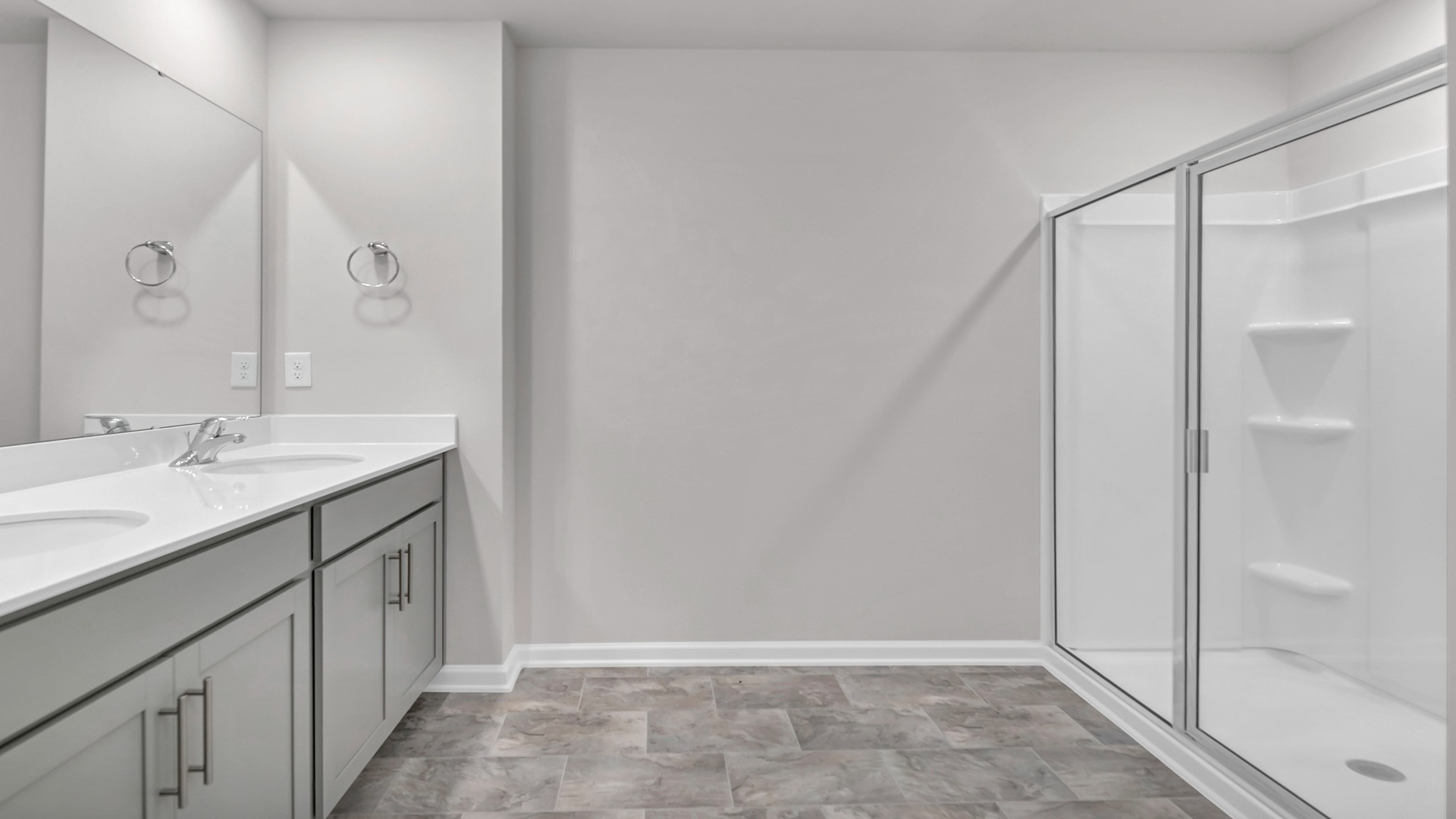 Primary bathroom with double vanity and standup shower