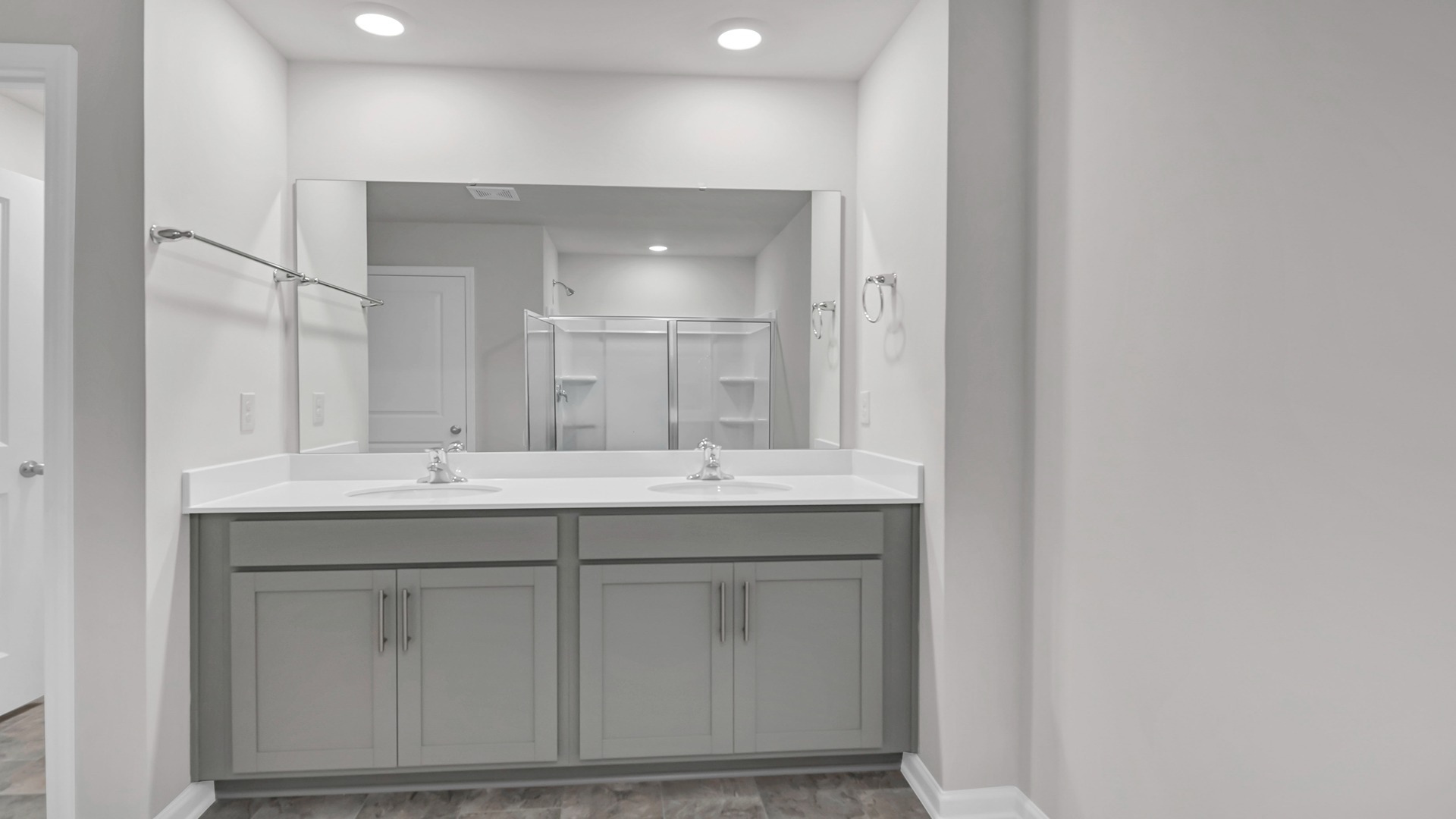 Primary bathroom with double vanity and standup shower