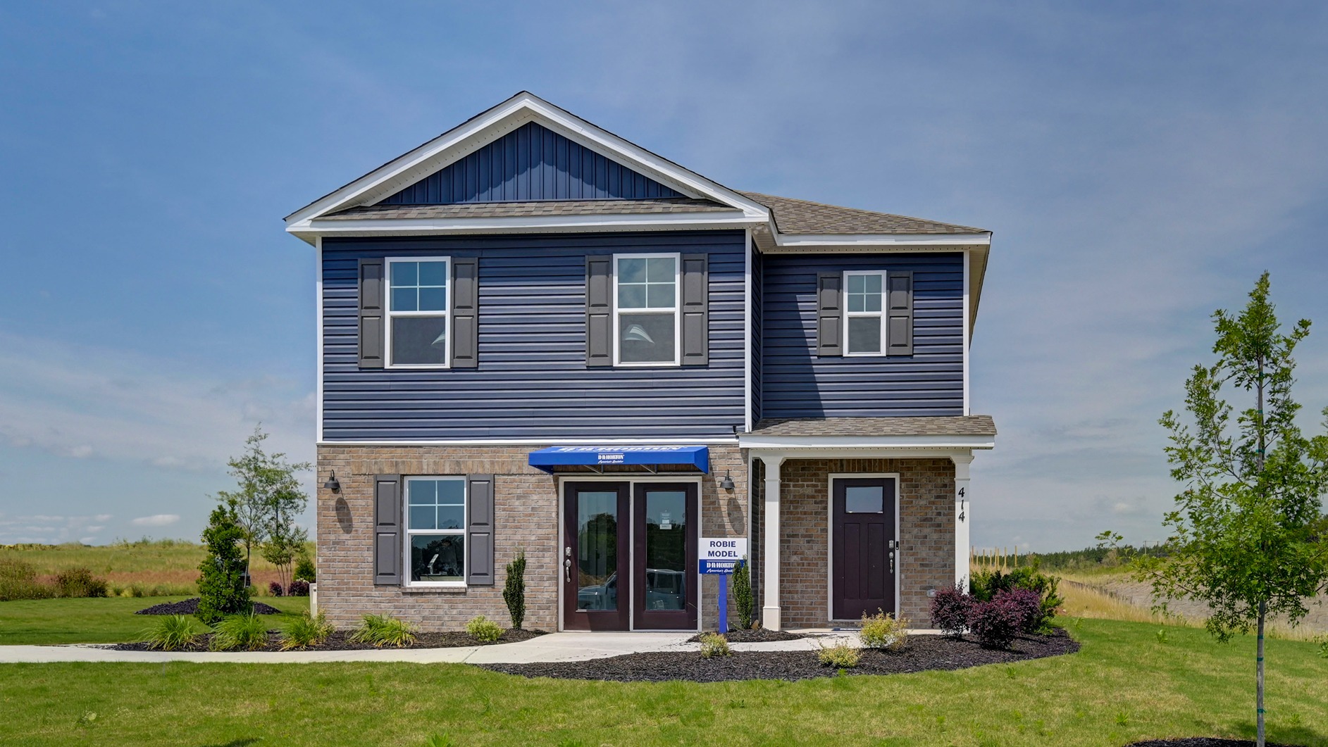 Two-story model home in Lexington, SC with blue vinyl siding and partial brick