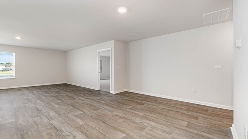 The living room is spacious with a window for natural light.