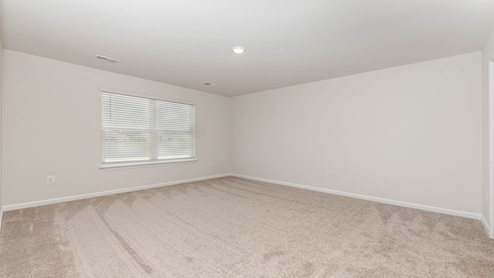 The Primary bedroom is spacious with several windows for natural light.
