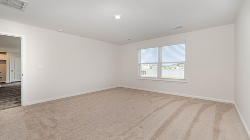 The Primary bedroom is spacious with several windows for natural light.