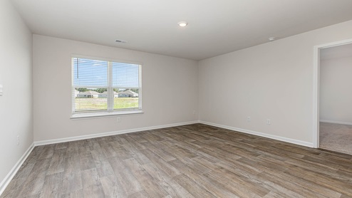 The living room is spacious with a window for natural light.
