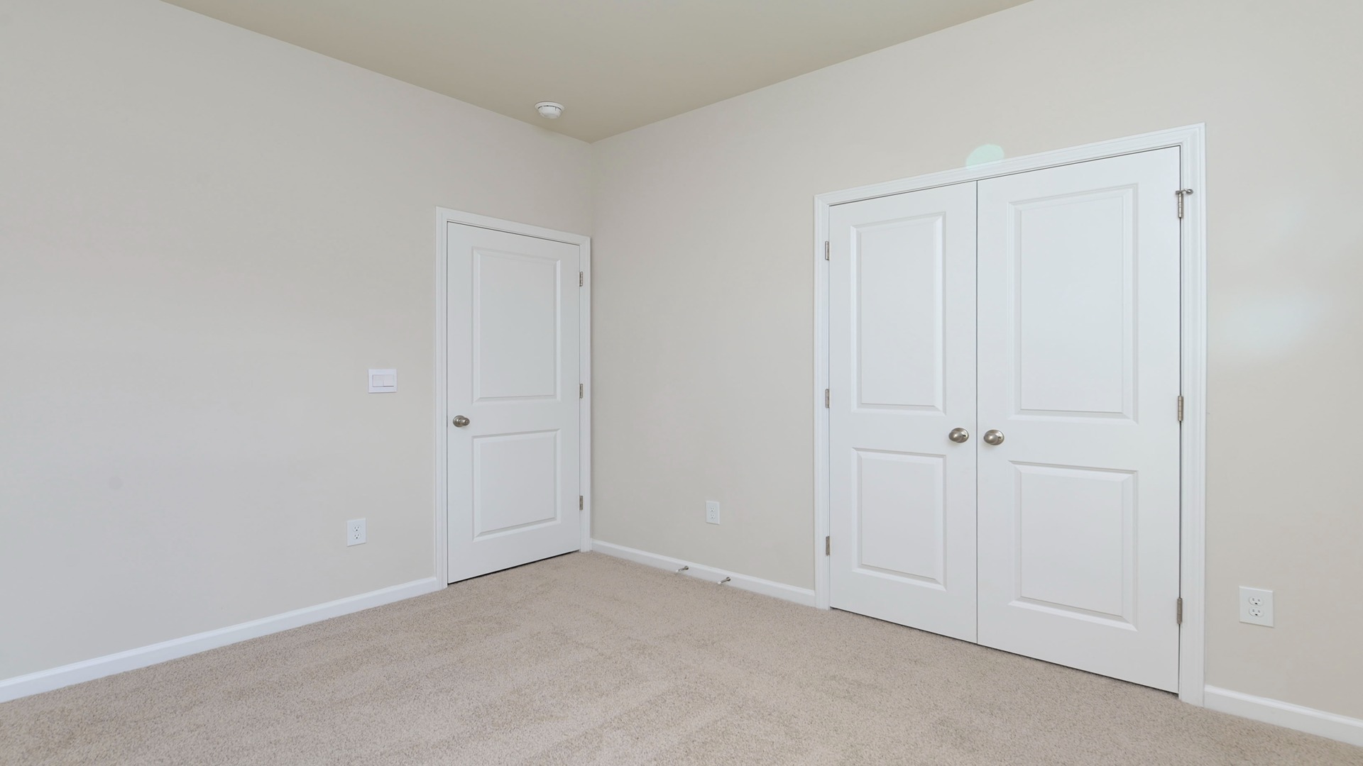 Carpet flooring and French closet doors in bedroom 2