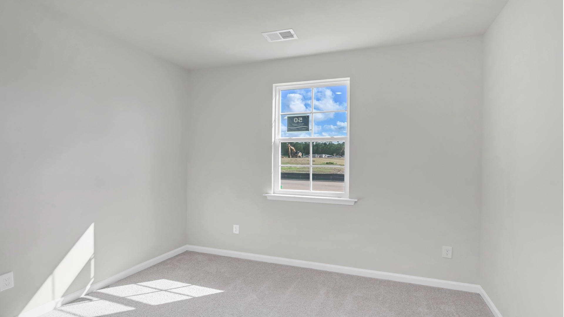 New construction home third bedroom with window and neutrally painted walls