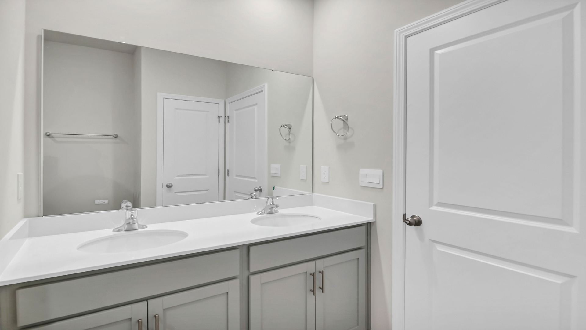Double primary vanity with gray cabinetry and quartz countertops