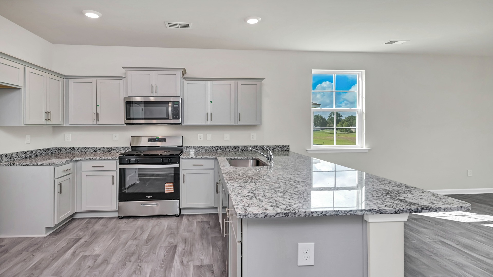 Cameron kitchen with gray cabinetry, a window for light, and a kitchen bar