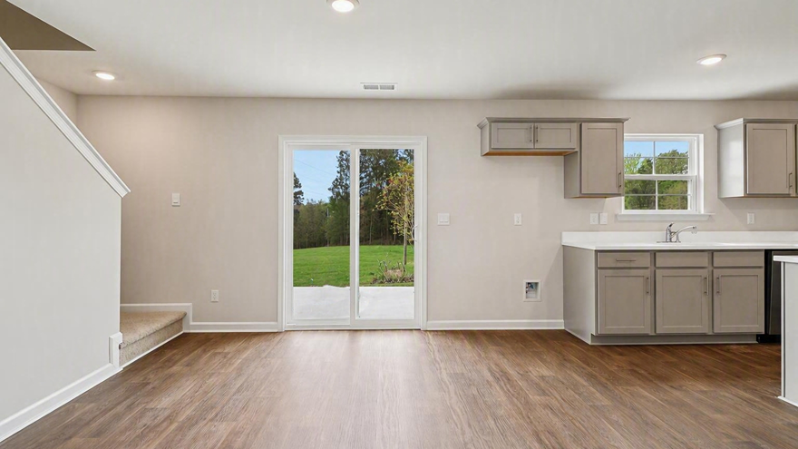 Dining area off the kitchen with matching vinyl floors and back glass sliding doors