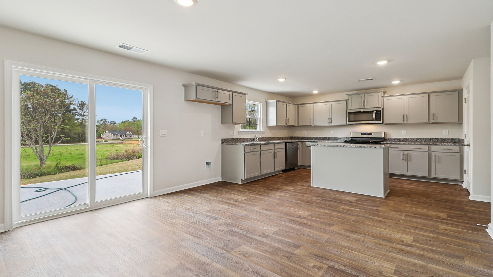 Open dining and kitchen spaces with vinyl flooring and lots of natural light
